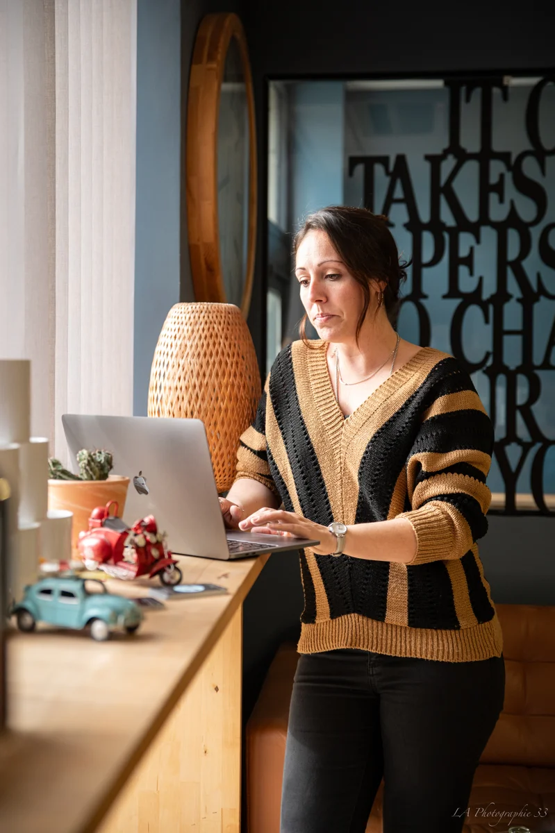 Femme travaillant sur son ordinateur portable dans un bureau lumineux et soigné