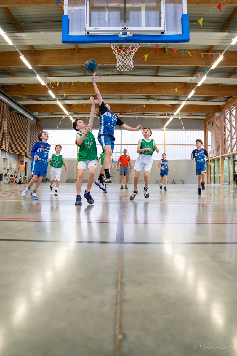Joueuses de basket en duel sous le panier lors d'un match en salle