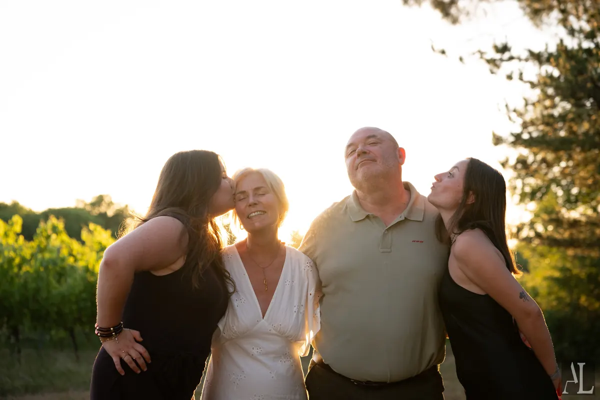 Portrait de famille complice au coucher de soleil dans les vignes
